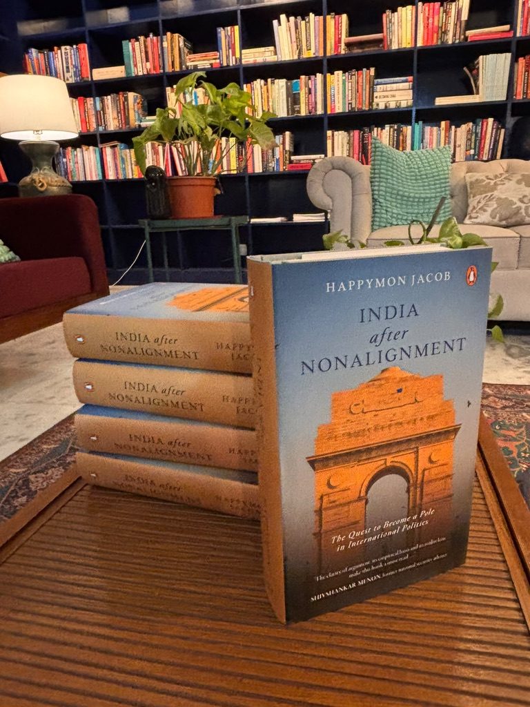 Copies of India after Nonalignment stacked on a table in a book-lined room